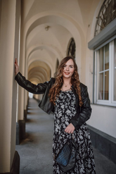 a lady in a floral printed dress and a black PU leather jacket